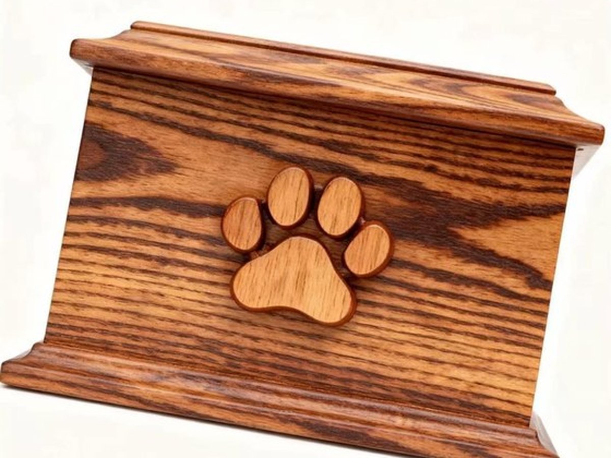 Oiled pine pet casket with a carved paw motif inlaid into the lid